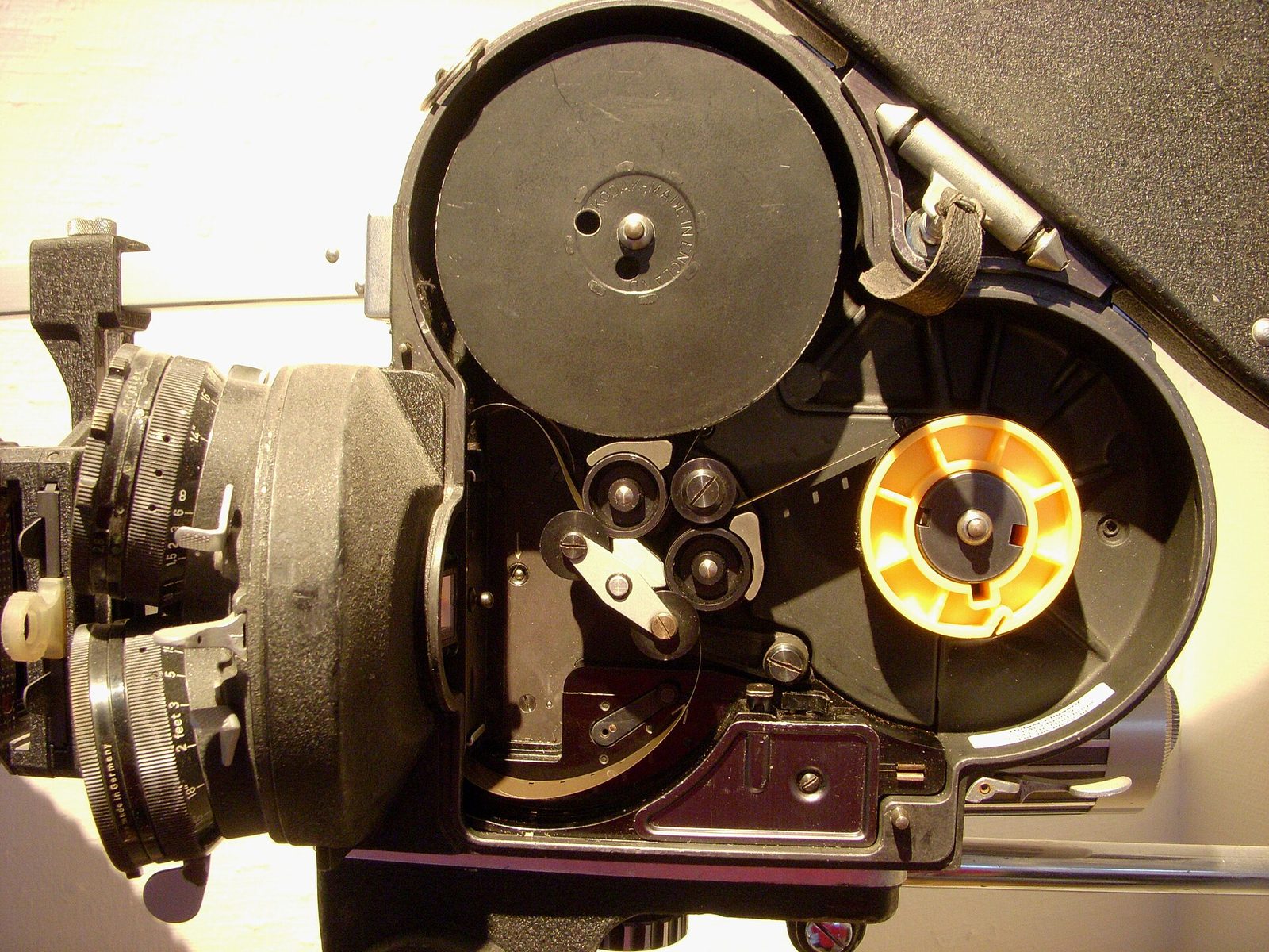 The open magazine and film path of an Arriflex 16 ST 16mm camera showing the take-up spool and sprocket rollers.